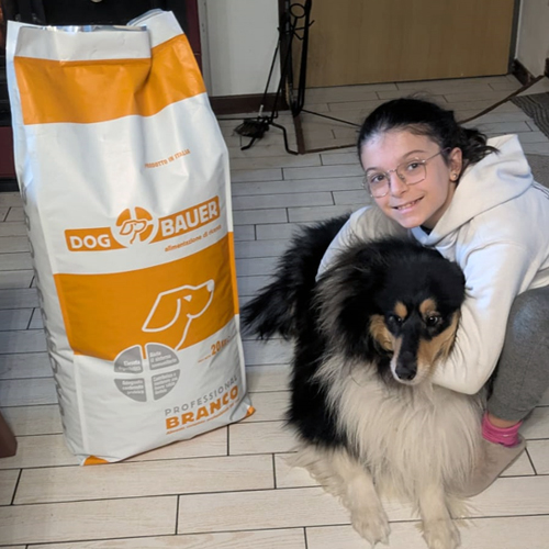 Ragazza inanellata con la sua Rottweiler e il sacco di crocchette Dogbauer