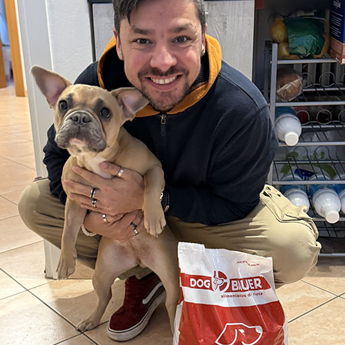 Ragazza che offre una crocchetta Dogbauer al suo cane Bovaro del Bernese e a fianco il sacco di crocchette Dogbauer Grain Free
